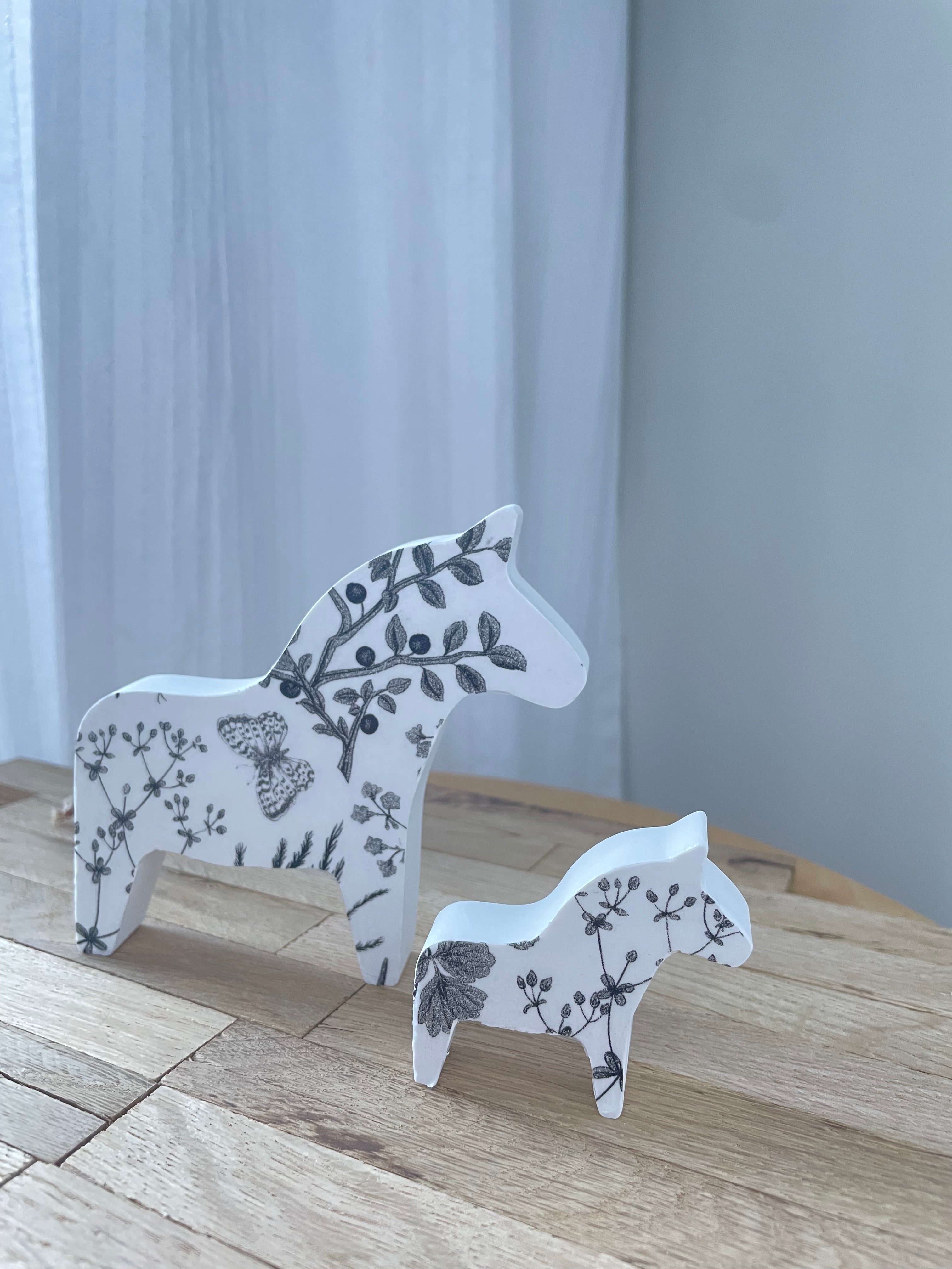 Handgefertigtes Dala-Pferd aus Keramik mit floralem Muster, liebevoll inszeniert – skandinavisch inspiriertes Wohnaccessoire für alle, die natürliche Details lieben.

