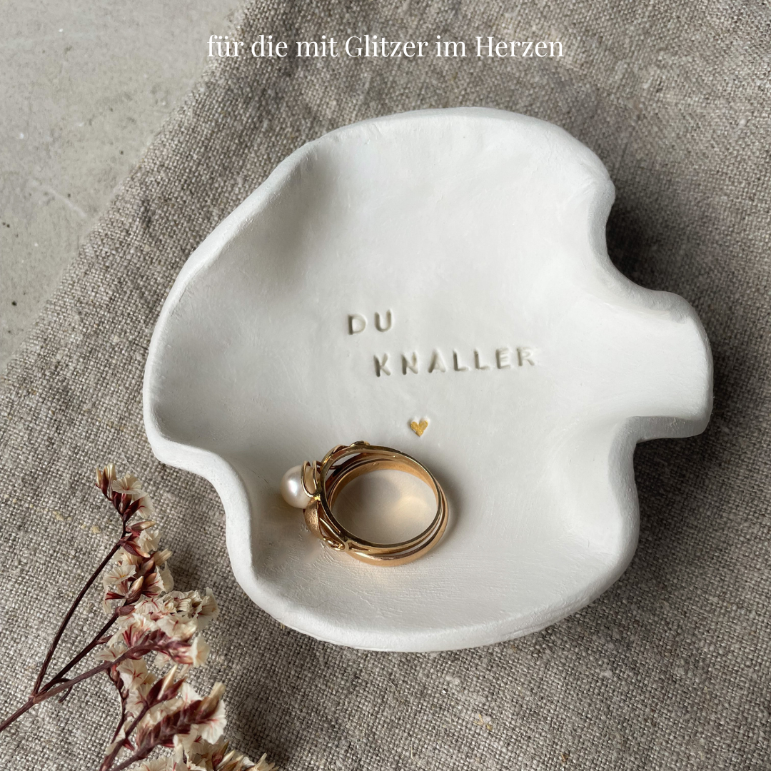 Handmade Schmuckschale aus Ton mit Schriftzug „Du Knaller“, goldener Herzprägung und organischer Form – perfekte Geschenkidee für Freundschaft, Geburtstag oder einfach so.

