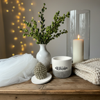 Handgefertigte Keramikdose mit weißem Körper und anthrazitfarbenem Dip-Dye. Der Deckel trägt einen strukturierten Keramikzapfen in Pantone Beige. Moderner, minimalistischer Look, perfekt als Schmuckdose oder Winterdeko. Fotografiert in einem hellen Winter-Interior mit Kerzenlicht und Naturmaterialien. Seidenmattes Finish, Einzelstück, sofort versandbereit.