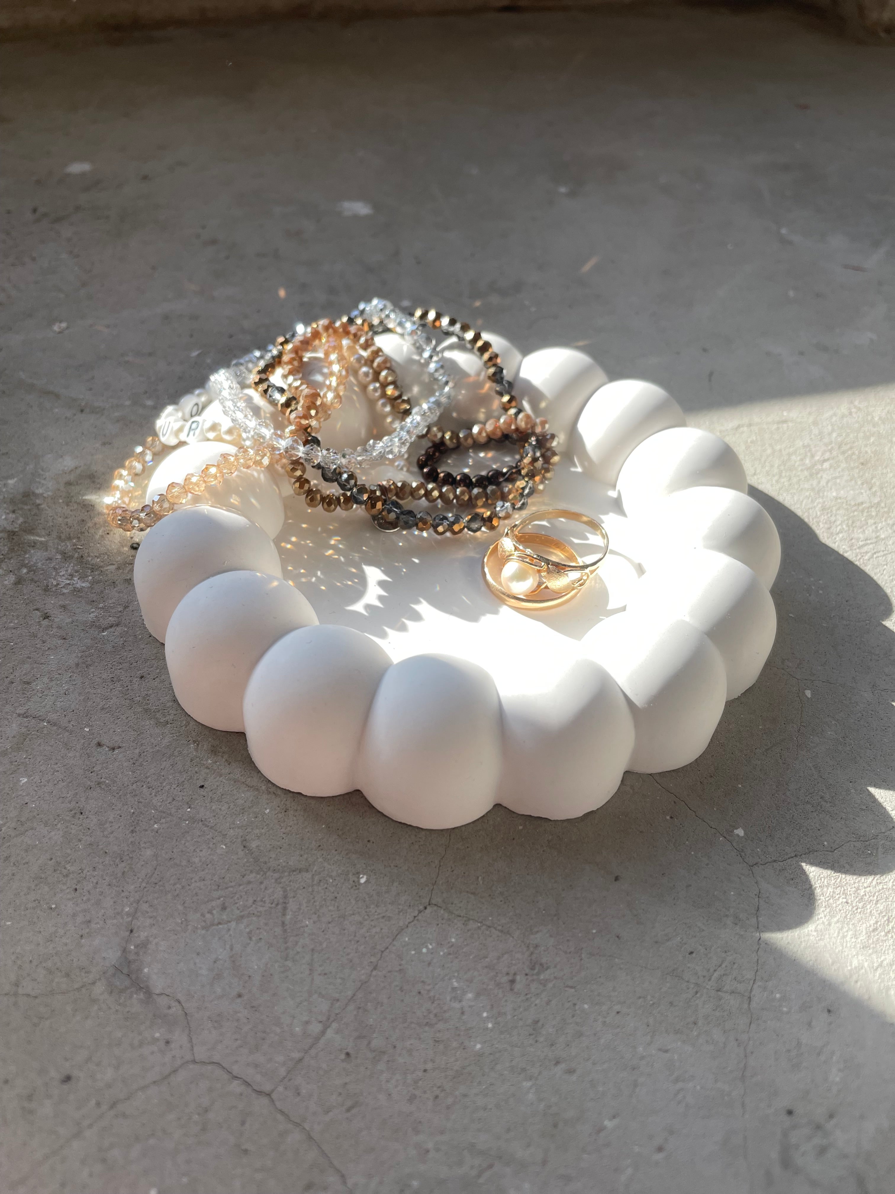 Runde Keramikschale im Bubble-Design, handgegossen und geschliffen. Die kugeligen Ränder erzeugen eine spielerische, moderne Optik. Perfekt für Nachttisch, Badezimmer oder Arbeitsplatz. Eignet sich als Schmuckschale oder Ablage für kleine Alltagsdinge. Helle Naturtöne, glatte Oberfläche und langlebige Keramik machen sie zu einem zeitlosen Dekoobjekt. Ideal für minimalistisches Interior, Geschenksets oder kleine Mitbringsel. für Mamas, Freundinnen, Kolleginnen und als Weihnachtsgeschenk