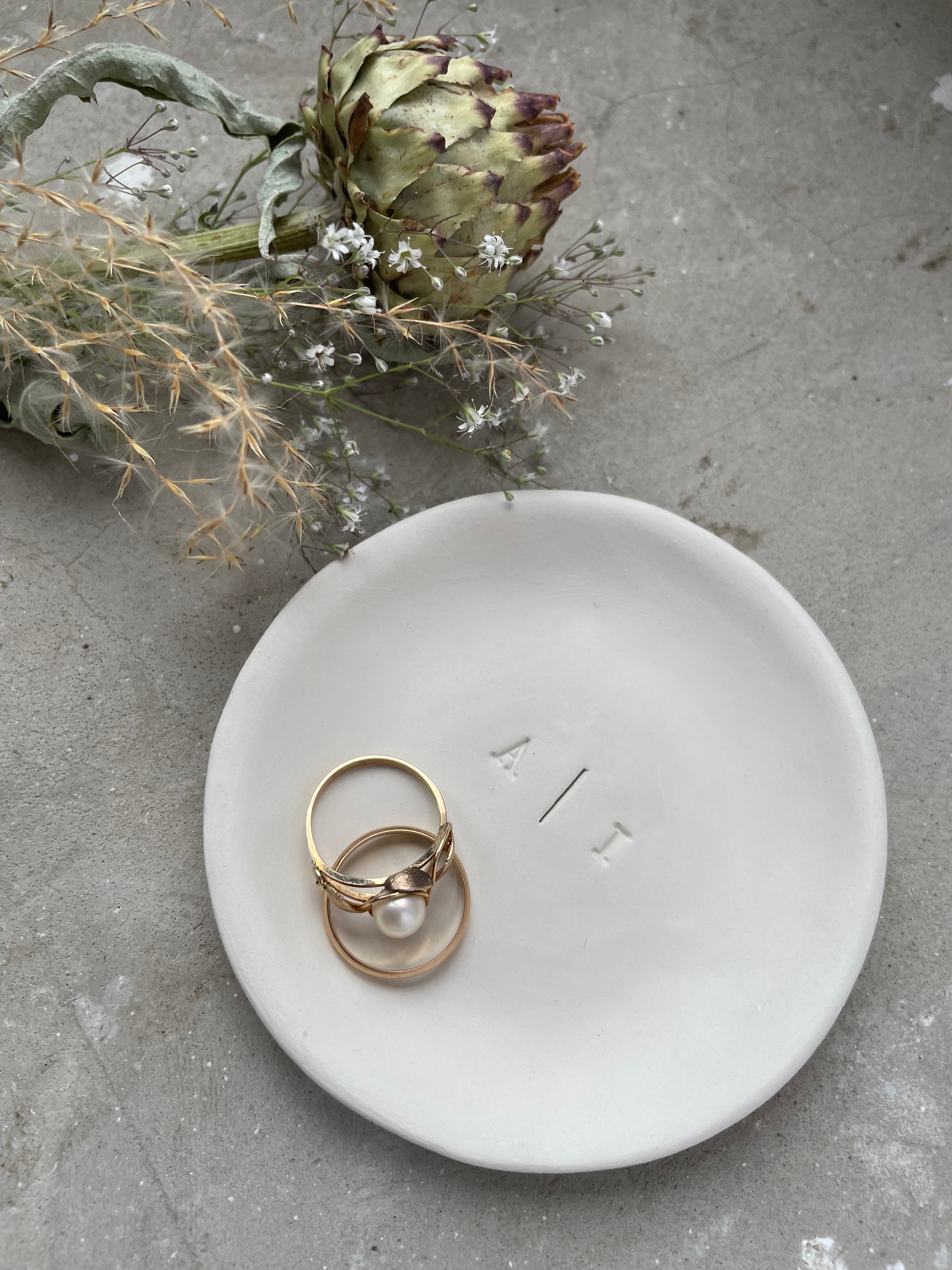 Schlichte Ringschale für die Hochzeit, aus echter Keramik, mit eleganter Gravur der Initialen in Typografie-Stil und dezentem Trennstrich – modernes Detail für stilvolle Trauungen