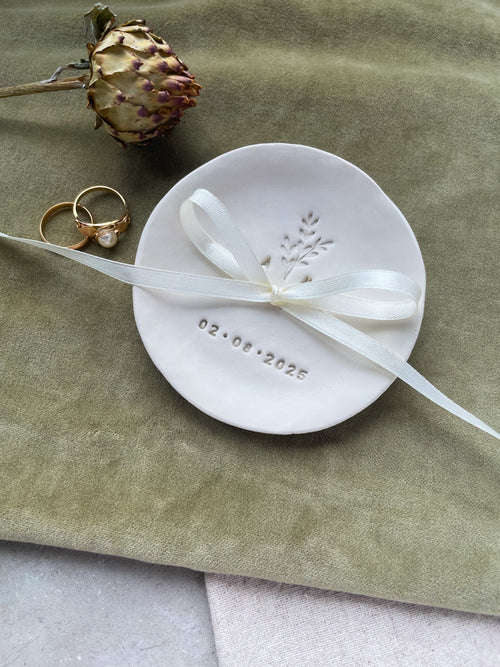 Handgefertigte Ringschale aus Keramik mit organischer Form, zarter Zweigprägung und personalisiert mit euren Initialen und Hochzeitsdatum – ein liebevoll gestaltetes Boho-Hochzeitsaccessoire, das Natürlichkeit und Symbolik vereint. Ideal für freie Trauungen, das Standesamt oder als Erinnerungsstück für euren großen Tag. Nachhaltig, einzigartig und mit Herz gemacht.

