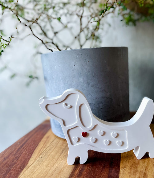 Weiße Keramikfigur „Dackel Anton“ mit rotem Herz – handgemachtes Geschenk für Hundefans, Hundemamas oder Menschen mit Herz am richtigen Fleck. Aus der kreativen Keramikwerkstatt Wortart-Manufaktur.

