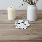 Stilvoller Frühlingsanhänger in Form einer Blüte mit detailliertem Relief und kleiner Vogel Applikation in Schwarz