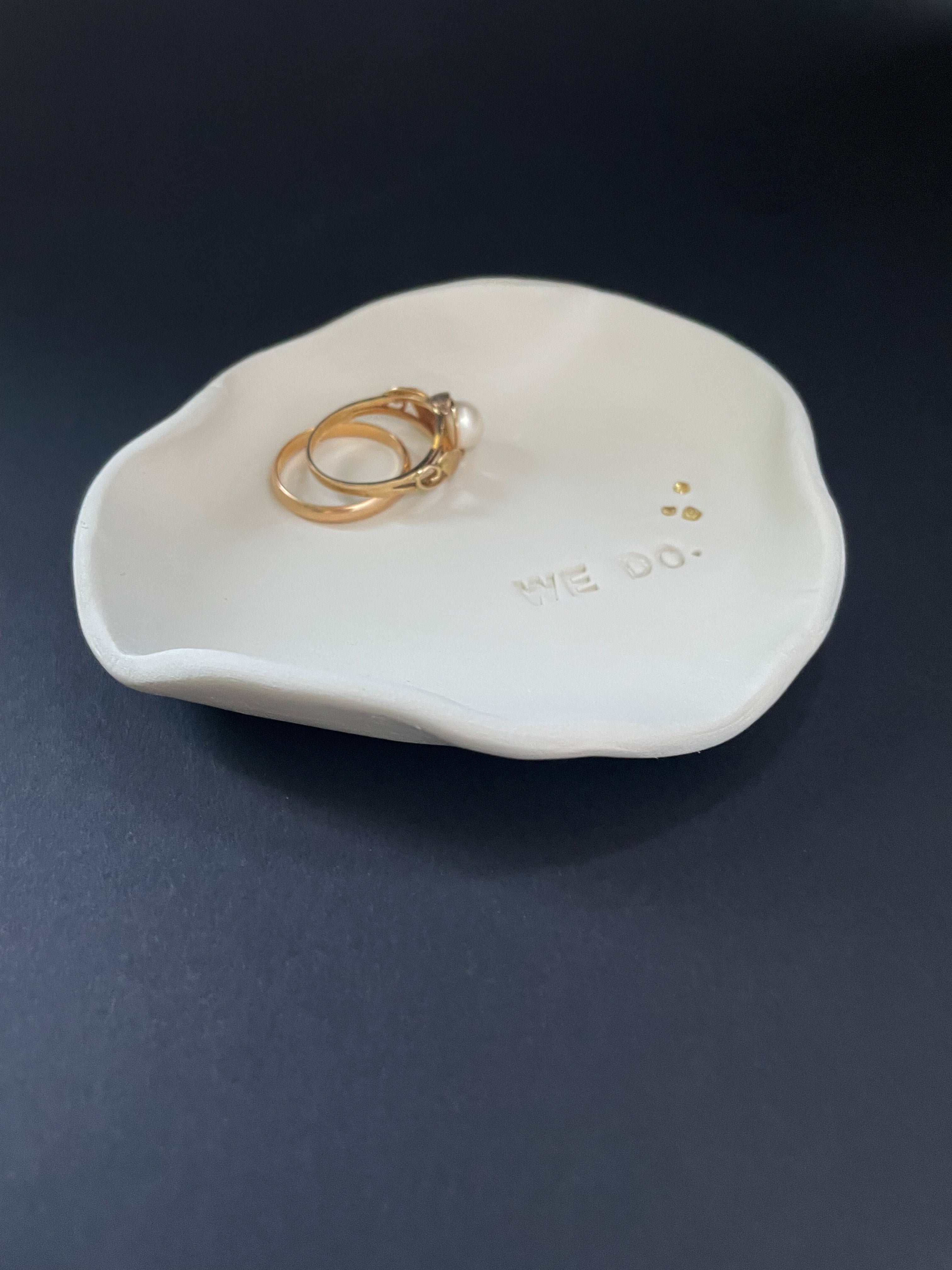 Edgy Ringschale mit klarer Form und „We do“-Schriftzug, minimalistisch inszeniert – für alle, die es pur, persönlich und ein bisschen anders mögen.

