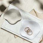 Minimalistische Keramikschale mit organischer Form, handgegossen aus hochwertiger Gießkeramik. Erhältlich in Weiß oder Pantone Toffee. Perfekt als kleine Ablage auf Coffee Table, Kommode, Badezimmerschrank oder Schreibtisch. Die ruhige Farbpalette und die glatte Oberfläche machen sie zu einem zeitlosen Interior-Element, das sich leicht kombinieren lässt. Jedes Stück hat kleine handmade-Spuren, die den Charakter unterstreichen.