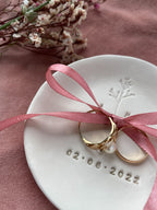 Personalisierte Hochzeitsdetails wie Ringschale, individuelle Deko und Blumen in Beerentönen – trendige Idee für freie Trauung oder Gartenhochzeit für nachhaltige Hochzeit mit biologisch abbaubarem Blütenkonfetti, natürlichen Farben und regionalen Blumen – Green Wedding Trend 2025