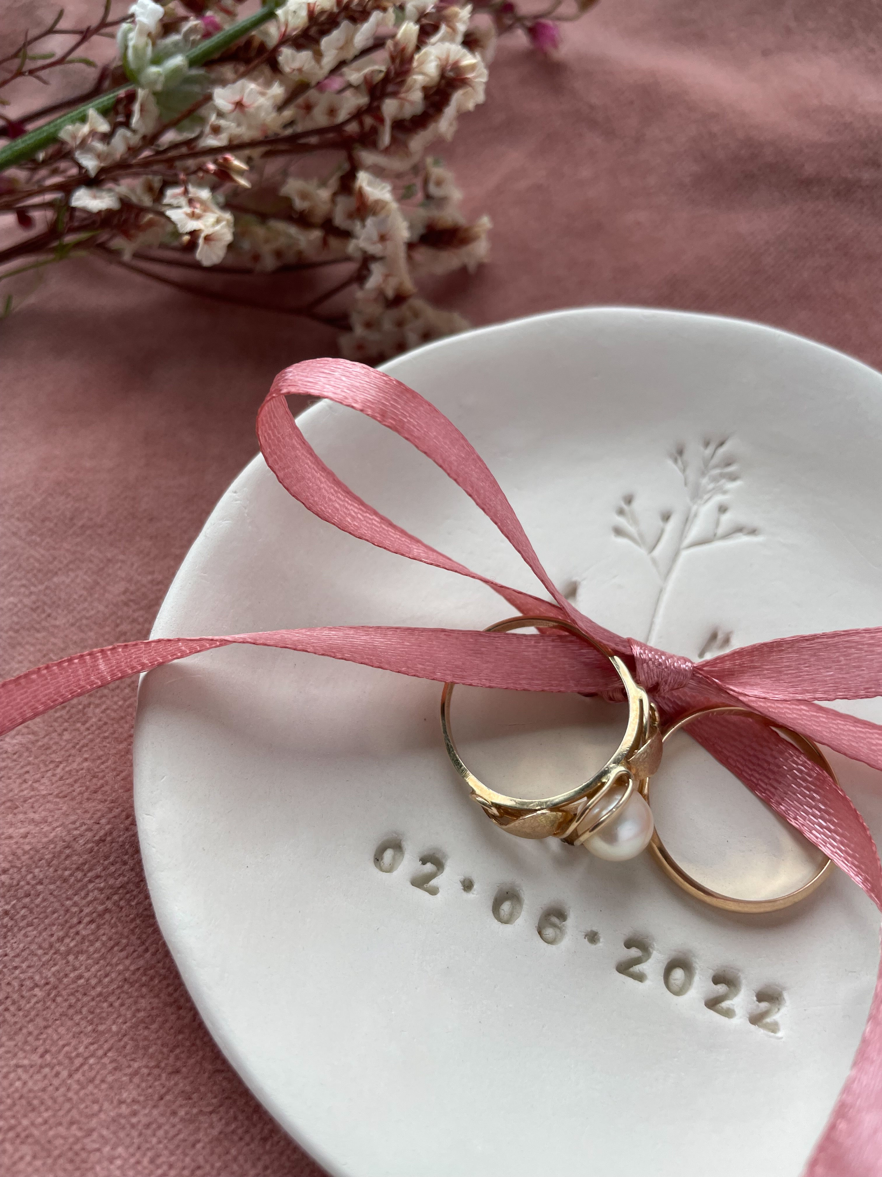 Personalisierte Hochzeitsdetails wie Ringschale, individuelle Deko und Blumen in Beerentönen – trendige Idee für freie Trauung oder Gartenhochzeit für nachhaltige Hochzeit mit biologisch abbaubarem Blütenkonfetti, natürlichen Farben und regionalen Blumen – Green Wedding Trend 2025