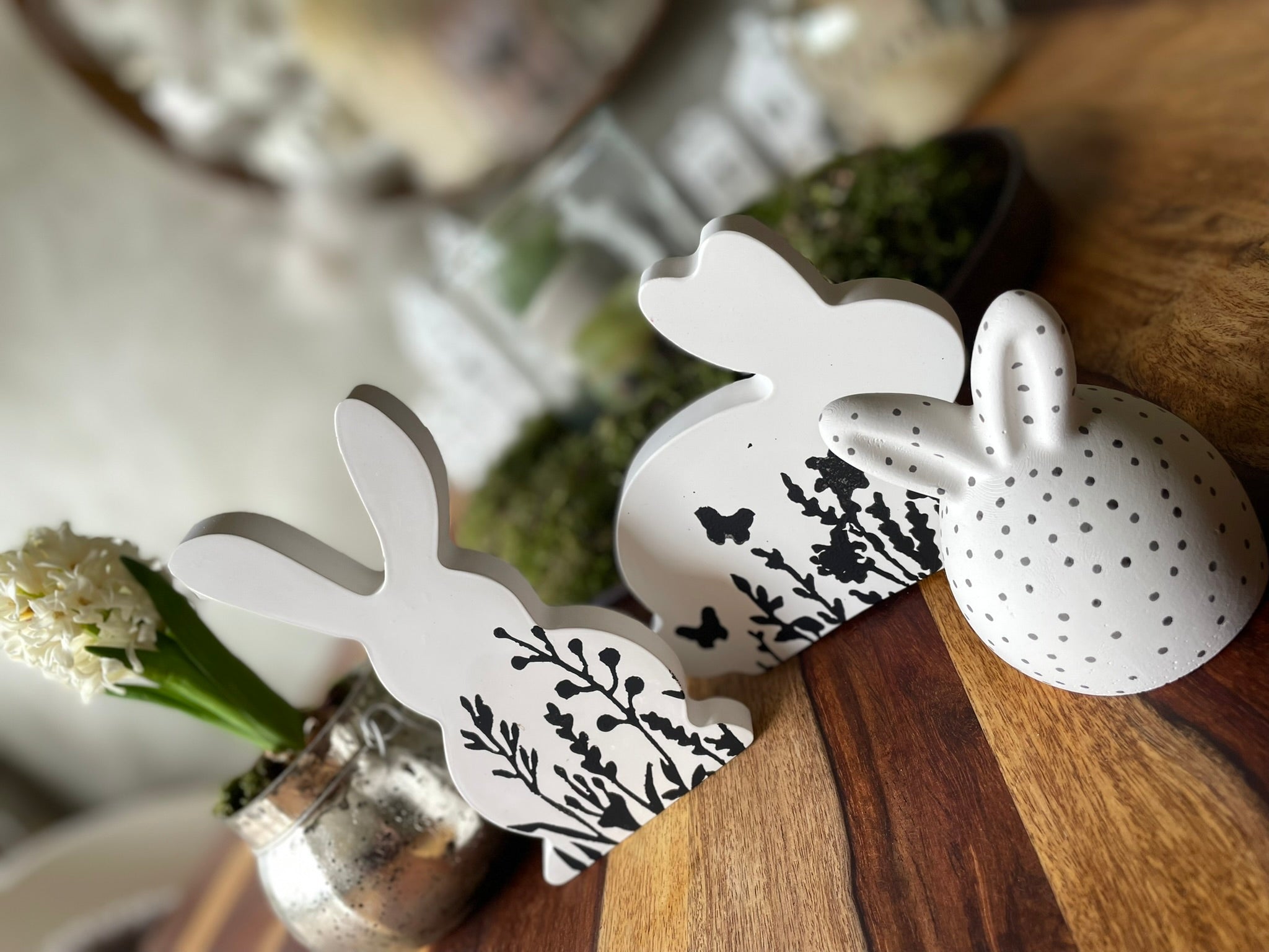 Set aus handgemachten Keramik Osterhasen in verschiedenen Größen die alle ein individuelles handgefertigtes Blütenmuster aus hochwertiger weißer Gussmasse tragen.