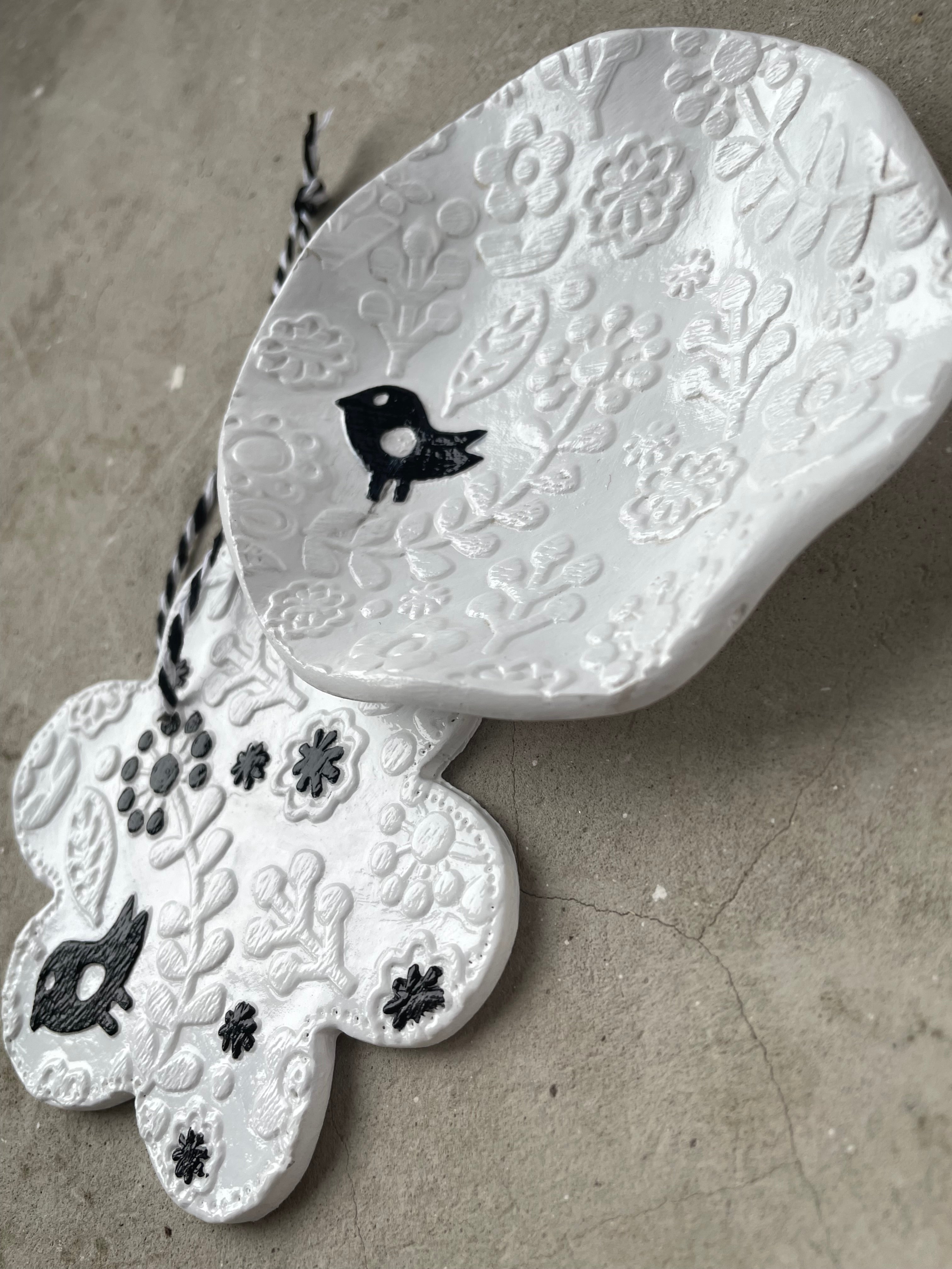 Kleine weiße Keramikschale mit einer zierlichen Vogel Figur am Rand für österliche Süßigkeiten