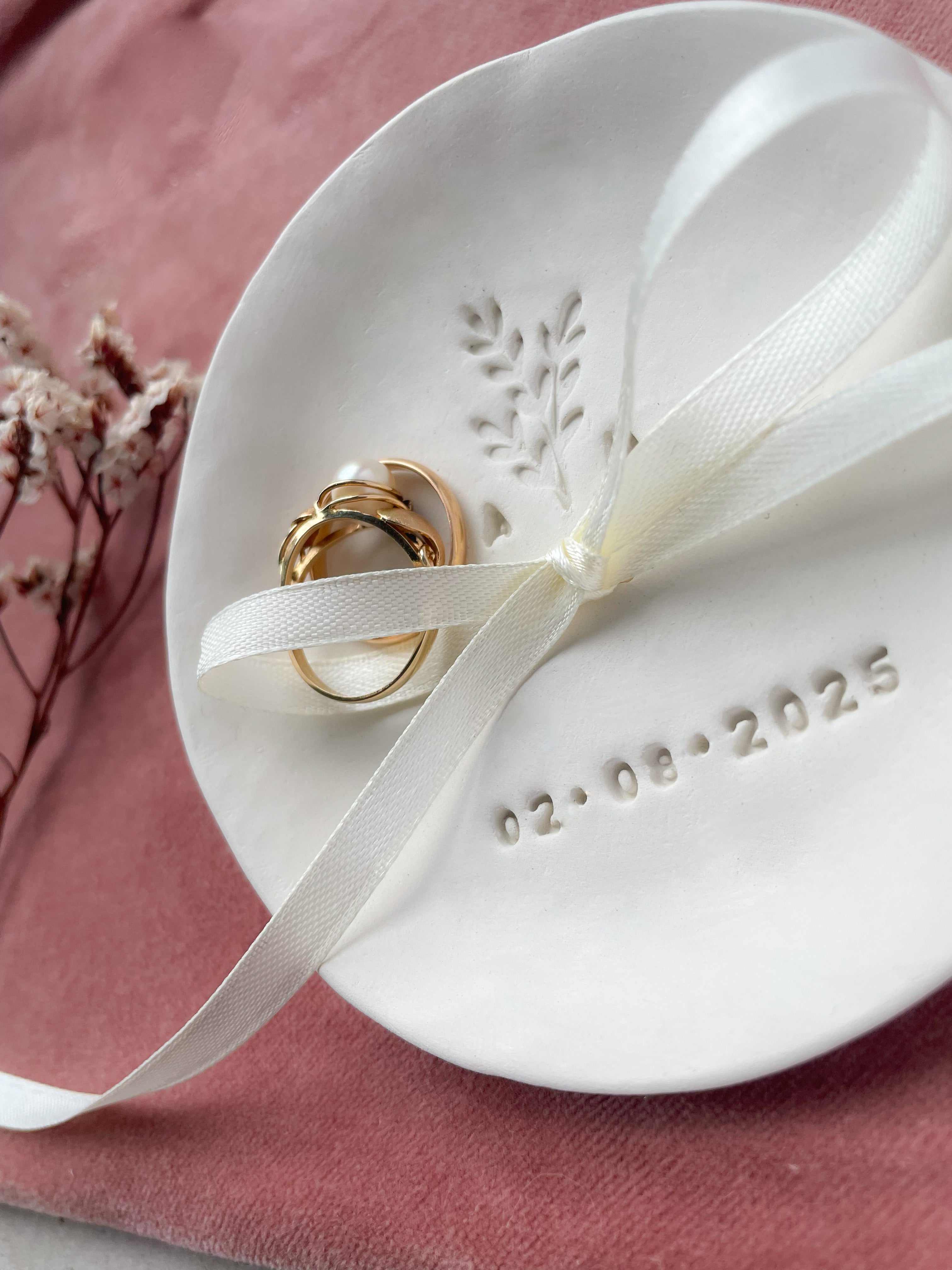 Boho-inspirierte Keramik-Ringschale mit handgeprägtem Zweig, Initialen und Datum – dekorativ inszeniert mit Trockenblumen und Naturmaterialien, perfekt für natürliche Hochzeiten im Grünen oder liebevolle freie Trauungen.

