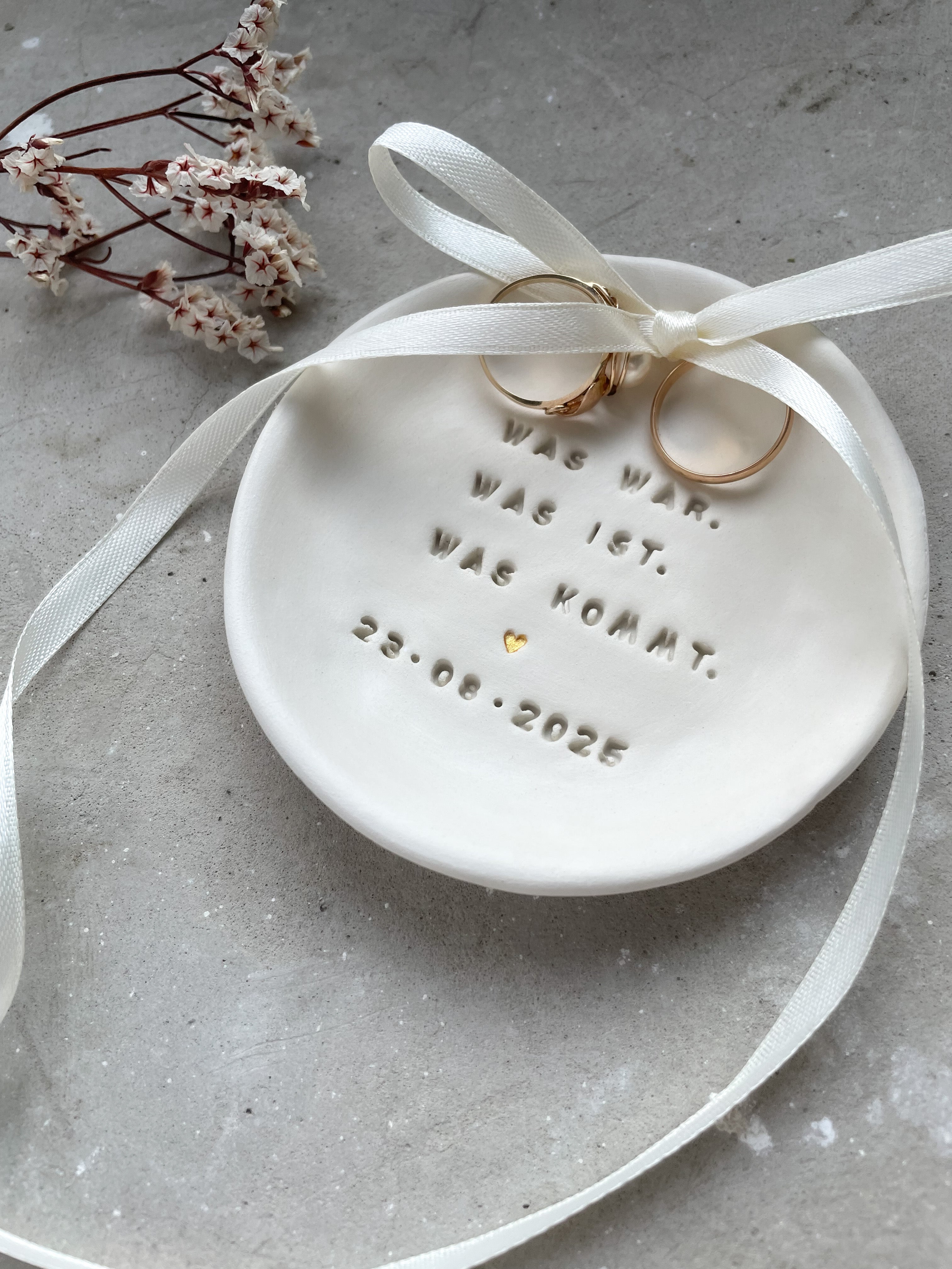 Minimalistische Ringschale für Trauringe, aus Premium-Steinzeug, handgetöpfert und fein glasiert. Wählbar mit Herz- oder Zweigprägung – schlicht, natürlich, elegant. Ideal für Boho-, Garten- und Winterhochzeiten. Seit 2018 entsteht in Deutschland echte Handwerkskeramik statt Massenware. Perfekt als Alternative zum Ringkissen und danach als Schmuckablage mit Bedeutung.